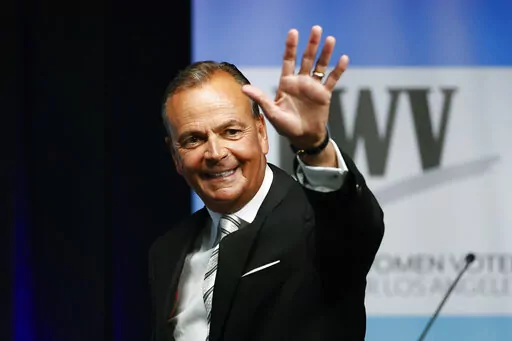 Businessman Rick Caruso waves at the start of a mayoral debate at the Student Union Theater on the California State University, Los Angeles campus on Sunday, May 1, 2022. Los Angeles is a heavily Democratic city, but voters this year could take a right turn. Caruso, a billionaire former longtime Republican who sits on the Ronald Reagan Presidential Foundation board, is a leading candidate for mayor and is promising to expand, not defund, police. (Ringo Chiu/Los Angeles Times via AP, File)