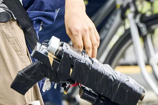 Suspect Tetsuya Yamagami holds a weapon, as he is detained near the site of gunshots in Nara, western Japan, Friday, July 8, 2022. The shooting of former Japanese Prime Minister Shinzo Abe sent shudders through low-crime, orderly Japan: A high-profile politician gets killed by a man emerging from a crowd, wielding a handmade firearm so roughly made it’s wrapped up in tape. (Nara Shimbun/Kyodo News via AP)