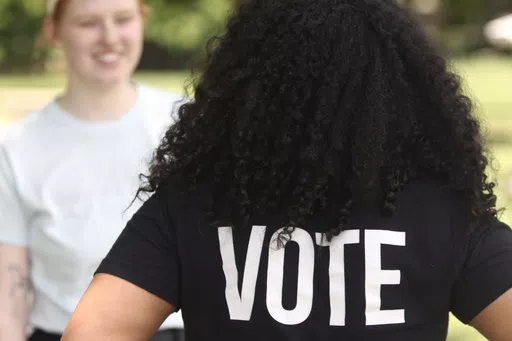 Anita Alexander, vice president for the Kansas group Loud Light, wears a T-shirt encouraging voting on the campus of Washburn University, Friday, May 18, 2024, in Topeka, Kan. Their group does voter registration drives on college campuses but has suspended that work while it challenges a state elections law that it says hampers registration drives. Laws passed in several Republican-controlled states are making it challenging for advocates to adapt as they try to register and educate potential vo