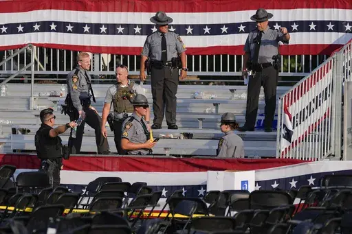 Law enforcement officers work at the campaign rally site for Republican presidential candidate former President Donald Trump is empty and littered with debris Saturday, July 13, 2024, in Butler, Pa. On Friday, July 19, The Associated Press reported on stories circulating online incorrectly claiming a law enforcement sniper assigned to Trump’s rally says the head of the Secret Service ordered him not to shoot the suspect accused of attempting to assassinate Trump.(AP Photo/Evan Vucci, File)