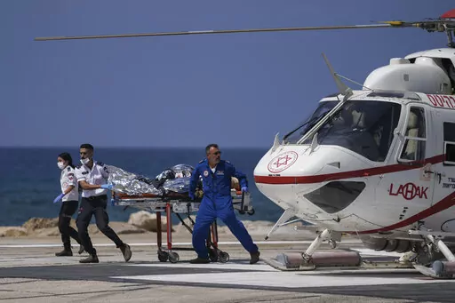 Israeli medics rush an injured man for treatment at the Rambam Hospital in the northern Israeli city of Haifa, following a shooting attack in the West Bank at the Jordan Valley, Sunday, Sept. 4, 2022. The Israeli military said that Palestinian gunmen opened fire on a bus in the occupied West Bank, wounding six soldiers, one of them seriously, and a civilian. (AP Photo/Ariel Schalit)