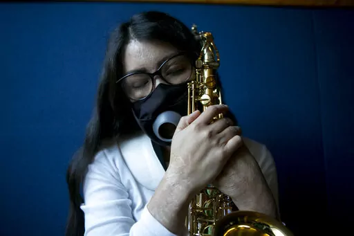 Maria Elena Ríos holds her saxophone at the end of a rehearsal at the National Autonomous University of Mexico music department, in Mexico City, Tuesday, Feb. 14, 2023. Ríos, 29, thought her career as a musician and her devotion to hersaxwas what ledherformer boyfriend and politician to hire the men who splashed acid into her faceand body, disfiguring her in 2019. Later, she learned that he simply couldn't accept that she had broken off their relationship. (AP Photo/Ginnette Riquelme)