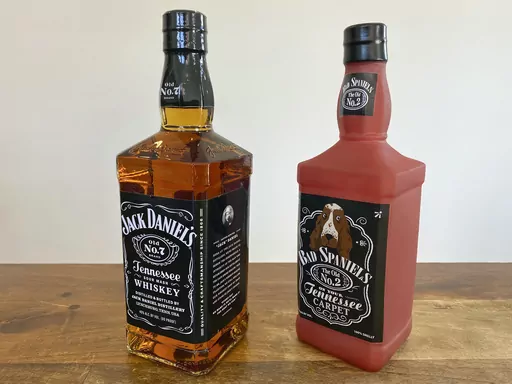A bottle of Jack Daniel's Tennessee Whiskey is displayed next to a Bad Spaniels dog toy in Arlington, Va., Nov. 20, 2022. The Supreme Court is hearing a dispute, Wednesday, March 22, 2023 between Jack Daniel’s and the manufacturer of the squeaking dog toy that parodies the liquor’s bottle and label. The question for the court has to do with whether the toy makers infringed on Jack Daniel’s trademarks. Arizona-based VIP Products produces the Bad Spaniels toy. While the original bottle has t