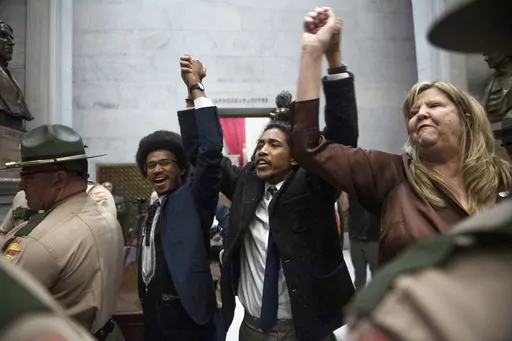 From left, Tennessee state Rep. Justin Pearson, state Rep. Justin Jones and state Rep. Gloria Johnson hold their hands up as they exit the House Chamber doors at Tennessee state Capitol Building in Nashville, Tenn., Monday, April 3, 2023. In Tennessee, three Democratic House members are facing expulsion for using a bullhorn in the House chamber to show support for pro-gun control protesters. In an increasingly polarized political atmosphere, experts say these kinds of harsh punishments for minor