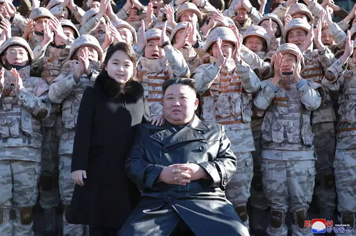 This undated photo provided on Nov. 27, 2022, by the North Korean government shows North Korean leader Kim Jong Un, center right, and his daughter, center left, with soldiers, pose for a photo,  following the launch of what it says a Hwasong-17 intercontinental ballistic missile, at an unidentified location in North Korea. Independent journalists were not given access to cover the event depicted in this image distributed by the North Korean government. The content of this image is as provided an