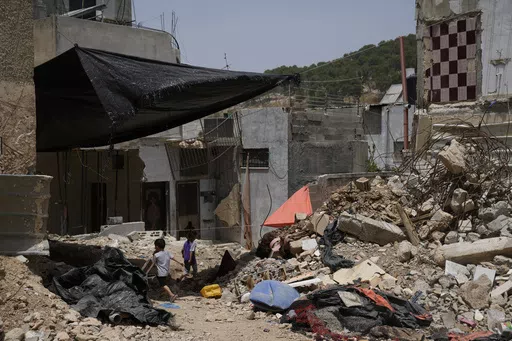 Palestinian children play by the rubble of buildings that were destroyed during Israeli army operations in the Nur Shams refugee camp in the West Bank on May 20, 2024. (AP Photo/Nasser Nasser)
