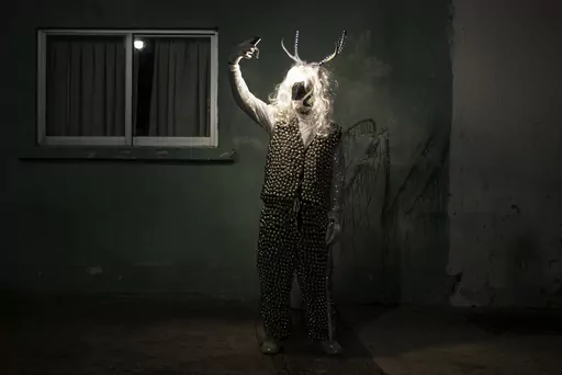 A man poses for a photo wearing a costume during a Muerteada parade in San Agustin Etla, Thursday, Nov. 2, 2023. Mexicans in the Oaxacan town celebrate the traditional Muerteada, a theatrical recreation that is performed through the night of November 1 until the early morning of the following day, with dances and music parading through the streets, while telling the story of how a deceased person is resurrected with the help of a priest, a doctor and a spiritist. (AP Photo/Maria Alferez)