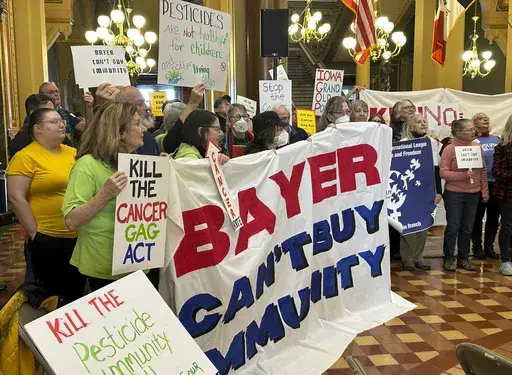 Protesters congregate at the Iowa state capitol building in Des Moines on Monday, Feb. 10, 2025, to rally against a bill that would protect pesticide companies from lawsuits that claim its popular weedkiller causes cancer. (AP Photo/Hannah Fingerhut)