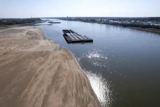 Barges float in the Mississippi River as a portion of the riverbed is exposed, Sept. 15, 2023, in St. Louis. (AP Photo/Jeff Roberson, File)