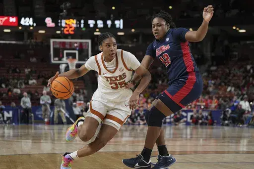 Texas forward Madison Booker (35) drives around Mississippi forward Christeen Iwuala (12) during an NCAA college basketball game in the quarterfinals of the Southeastern Conference tournament, Friday, March 7, 2025, in Greenville, S.C. (AP Photo/David Yeazell)