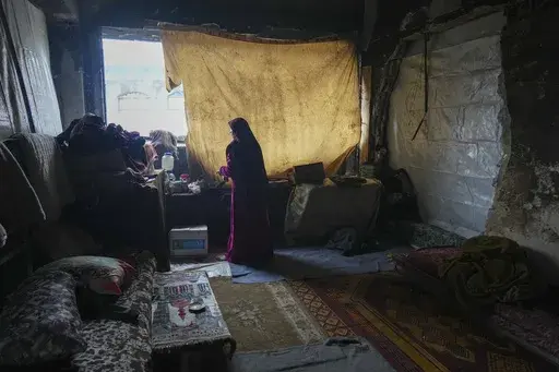 Hanan Okal, 22, prepares breakfast for her children inside a classroom in the Jabaliya Girls Preparatory School, which displaced people use as a shelter, in the Jabaliya refugee camp in the northern Gaza Strip, Monday, Feb. 10, 2025. (AP Photo/Abdel Kareem Hana)