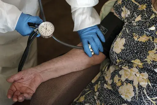 A doctor checks the blood pressure of A 94-year-old woman in Sant Sadurní d'Anoia, Catalonia region, Spain, Friday, July 31, 2020. (AP Photo/Felipe Dana, File)