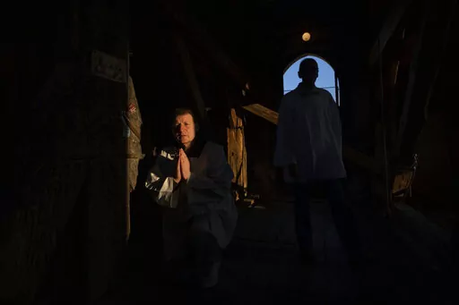 Retired policeman, Volodymyr Ilnytskyi, 55, prays before ringing the bell of the Latin Cathedral in Lviv, western Ukraine, Thursday, March 24, 2022. (AP Photo/Nariman El-Mofty)