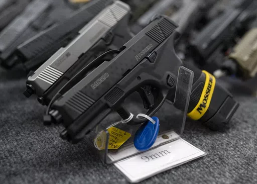 Pistols sit on display during the first day of the Silver Spur Gun and Blade Show, Jan. 22, 2022, in Odessa, Texas. On Monday, May 20, 2024, a federal judge blocked the Biden administration from enforcing a new rule in Texas that would require firearms dealers to run background checks on buyers at gun shows or other places outside brick-and-mortar stores. (Eli Hartman/Odessa American via AP, File)