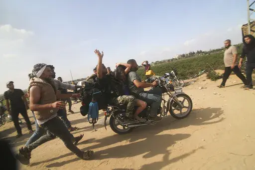Palestinians transport a captured Israeli civilian, Noa Argamani, on a motorcycle from southern Israel, in the Gaza Strip on Oct. 7, 2023. Victims of Hamas' Oct. 7 attack in Israel sued Iran, Syria and North Korea on Monday, July 1, 2024, saying their governments supplied the militants with money, weapons and know-how needed to carry out the assault that precipitated Israel's ongoing war in Gaza. (AP Photo)