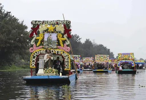 A relic of St. Jude Thaddeus is transported in a glass urn on a trajinera through the canals of Xochimilco, Mexico City, Sunday, Aug. 11, 2024. (AP Photo/Ginnette Riquelme)