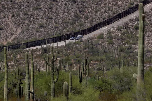 U.S. Customs and Patrol Patrol agents sit along a section of the international border wall that runs through Organ Pipe Cactus National Monument, Thursday, Aug. 22, 2019 in Lukeville, Ariz. U.S. Border Patrol agents answering reports of gunfire shot and killed a man on a tribal reservation in southern Arizona after he abruptly threw something and raised his arm, the agency said Monday, May 22, 2023. (AP Photo/Matt York, File)