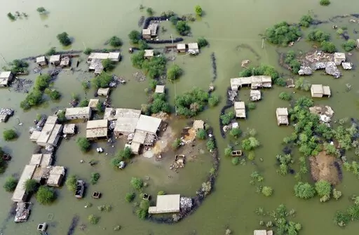 Homes are surrounded by floodwaters in Sohbat Pur city, a district of Pakistan's southwestern Baluchistan province, Aug. 30, 2022. This past year has seen a horrific flood that submerged one-third of Pakistan, one of the three costliest U.S. hurricanes on record, devastating droughts in Europe and China, a drought-triggered famine in Africa and deadly heat waves all over. (AP Photo/Zahid Hussain, File)