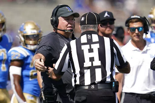 UCLA head coach Chip Kelly talks with an official during the first half of an NCAA college football game against Utah in Pasadena, Calif., Saturday, Oct. 8, 2022. (AP Photo/Ashley Landis)