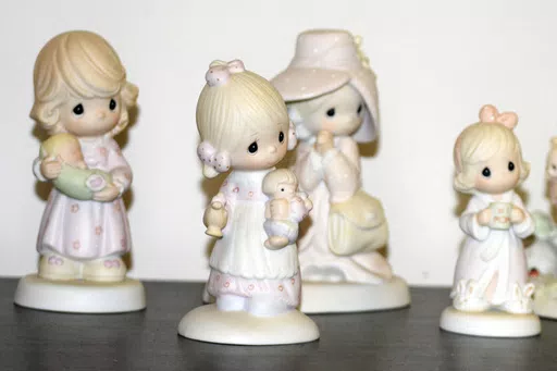 A selection of Precious Moments figurines sit on a shelf, Thursday, May 23, 2024, in Blaine, Minn. Sam Butcher, the artist who created the Precious Moments figurines depicting angelic teardrop-eyed children, died early Monday, May 20, 2024, surrounded by family. He was 85. (Lissa Forliti-Aska via AP)