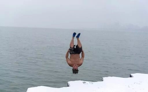 "The Great Lake Jumper" Dan O'Conor takes a plunge into the frigid waters of Lake Michigan, as he does every morning, Thursday, Jan. 26, 2023, in Chicago. O'Conor has jumped every day since June 2020. Celebrities and regular folk are plunging into frigid water for their social media feeds, but the science on the supposed benefits is lukewarm.(AP Photo/Erin Hooley)