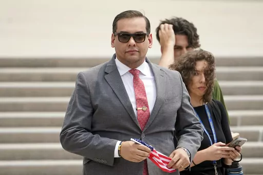 U.S. Rep. George Santos, R-N.Y., holds a miniature American flag that was presented to him as he departs federal court, Friday, June 30, 2023, in Central Islip, N.Y. Sam Miele, a former political fundraiser for Santos, was arrested Wednesday, Aug. 16, on federal charges of wire fraud and aggravated identity theft as part of an alleged scheme to trick donors into giving money to Santos under a false name. (AP Photo/John Minchillo, File)