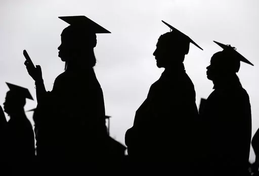 In this May 17, 2018, file photo, new graduates line up before the start of the Bergen Community College commencement at MetLife Stadium in East Rutherford, N.J.  A deadline is fast approaching for teachers, librarians, nurses and others who work in public service to apply to have their student loan debt forgiven. New figures from the U.S. Department of Education show 145,000 borrowers have had the remainder of their debt canceled through the Public Service Loan Forgiveness program. (AP Photo/Se