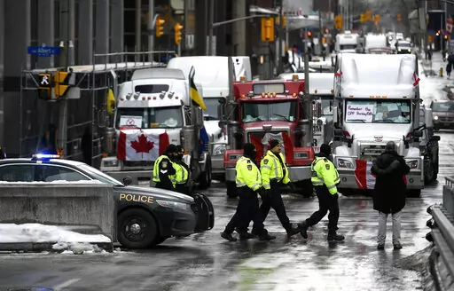 Police officers patrol on foot along Albert Street as a protest against COVID-19 restrictions continue in Ottawa, Thursday, Feb. 10, 2022. On Friday, Feb. 11, 2022, The Associated Press reported on stories circulating online incorrectly claiming half of the police officers in Canada’s capital city resigned on Monday in support of protests against vaccine requirements. (Justin Tang /The Canadian Press via AP, File)