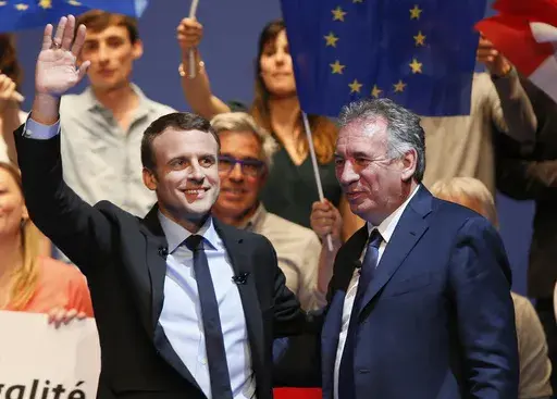French centrist presidential election candidate Emmanuel Macron, left, waves supporters as French centrist politician Francois Bayrou looks on during a meeting in Pau, southwestern France, Wednesday, April 12, 2017. (AP Photo/Bob Edme, File)