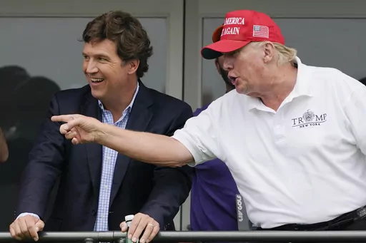 Tucker Carlson, left, and former President Donald Trump, talk while watching golfers on the 16th tee during the final round of the LIV Golf Invitational at Trump National in Bedminster, N.J., July 31, 2022. A defamation lawsuit against Fox News is revealing blunt behind-the-scenes opinions by its top figures about Donald Trump, including a Tucker Carlson text message where he said “I hate him passionately.” Carlson's private conversation was revealed in court papers at virtually the same tim