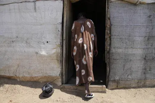 A 28-year-old mother of four who was gang-raped by armed men while collecting firewood, enters a makeshift house in Juba displacement camp, South Sudan, Wednesday, Feb. 12, 2025. (AP Photo/Brian Inganga)