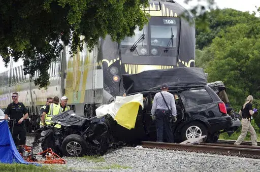 In this Aug 25, 2019 file photo, Broward Sheriff's Deputies and Pompano Beach Fire Rescue work the scene of a fatal accident on North Dixie Highway in Pompano Beach, Fla. South Florida's higher-speed railroad, other train lines and local officials  met with federal safety officials Wednesday, Feb. 23, 2022 to begin working out plans that they hope will decrease the number of fatal strikes between locomotives, cars and pedestrians. (Joe Cavaretta/South Florida Sun-Sentinel via AP)