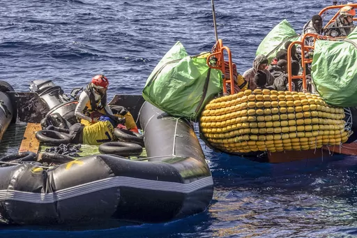 A migrant is helped evacuate a partially deflated rubber dinghy by the rescue personnel of the SOS Mediterranee humanitarian ship Ocean Viking in the Central Mediterranean Sea, Wednesday, March 13, 2024, Survivors reported that some 50 people who departed Libya with them a week ago had perished during the journey. (Johanna de Tessieres/ SOS Mediterranee via AP, HO)