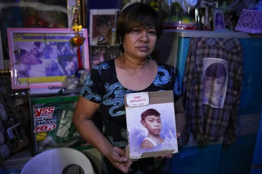 Emily Soriano holds a picture of her 15-year-old son as she recounts how he was gunned down with four friends and two other residents while partying in a Philippine slum six years ago during an interview with the Associated Press at their home in Manila, Philippines on June 23, 2022. With Philippine President Rodrigo Duterte set to step down on June 30, 2022 at the end of his turbulent six-year term, Soriano and other relatives, who say their loved ones were victims of extrajudicial killings und