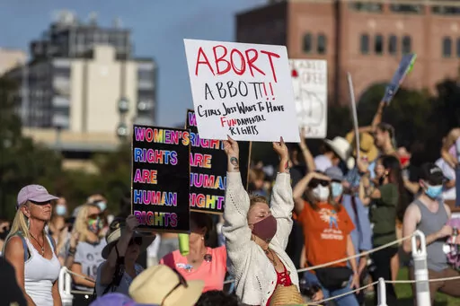 FILE - People attend the Women's March ATX rally, Saturday, Oct., 2, 2021, at the Texas State Capitol in Austin, Texas.  An expected decision by the U.S. Supreme Court in the coming year to severely restrict abortion rights or overturn Roe v. Wade entirely is setting off a renewed round of abortion battles in state legislatures. (AP Photo/Stephen Spillman, File)