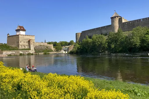 Men are seen fishing near the fortresses of Narva, left, in Estonia, and Ivangorod, right, in Russia, on Wednesday, May 24, 2023. The two countries took radically different paths after the Soviet Union's collapse, and an Associated Press correspondent who was in Moscow for almost all of Vladimir Putin’s rule until earlier this year has watched Russia’s steps forward as well as its retreat into isolation. Now assigned to Estonia, he tries to parse Russia's lost promise. (AP Photo/Jim Heintz, 
