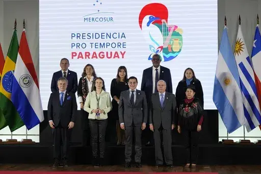 Foreign ministers, front row, and staff pose for a photo ahead of a Mercosur summit at the Port building in Asuncion, Paraguay, Sunday, July 7, 2024. From left are Uruguay's Omar Paganini, Argentina's Diana Mondino, Paraguay's Ruben Ramirez, Brazil's Mauro Vieira and Bolivia's Celinda Sosa. (AP Photo/Jorge Saenz)