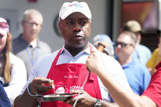 Republican presidential candidate Sen. Tim Scott, R-S.C., eats pork after working the grill at the Iowa Pork Producers tent at the Iowa State Fair, Tuesday, Aug. 15, 2023, in Des Moines, Iowa. (AP Photo/Charlie Neibergall)