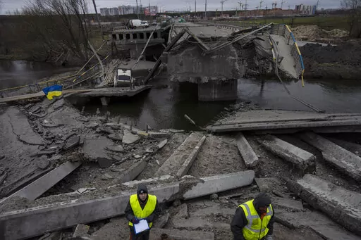 Engineers inspect the state of destruction of the bridge that connects Kyiv with Irpin, Ukraine, Wednesday, April 13, 2022. (AP Photo/Rodrigo Abd)