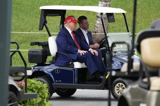 President Donald Trump, driven by his son Eric Trump, arrives at Trump National Doral during the LIV Golf Miami tournament, Thursday, April 3, 2025, in Miami. (AP Photo/Alex Brandon)