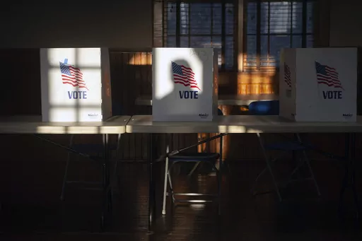 The shadow of a voter entering the precinct at St. Joseph Catholic Church in Gluckstadt, Miss., is cast on a privacy divider for people filling out ballots at Precinct 205 at during the primary election Tuesday, March 12, 2024. (Barbara Gauntt/The Clarion-Ledger via AP)