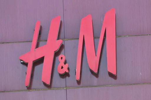 The logo of Swedish clothing-retail company Hennes & Mauritz (H&M) is pictured in Velizy, outside Paris, France, Wednesday, Sept. 20, 2017. A pioneering bill to curb the rampant pace of fast fashion won unanimous approval in the French Parliament, making France one of the first countries in the world to target the influx of low-cost, mass-produced garments. (AP Photo/Michel Euler)