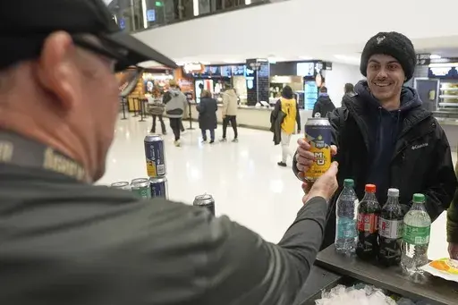 Jimmy Gross serves Jonathon Holdway some Third Space Marquette beer before an NCAA college basketball game Tuesday, Feb. 11, 2025, in Milwaukee. (AP Photo/Morry Gash)