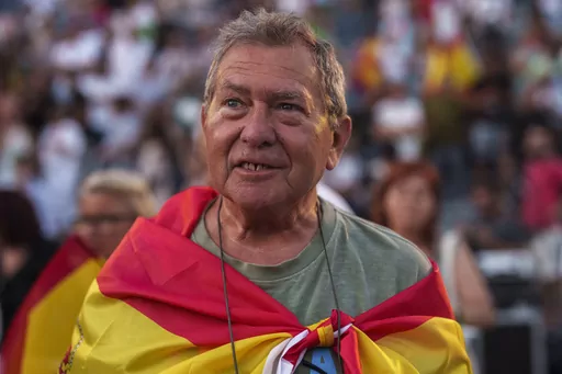 A supporter of VOX far right party wrapped in a Spanish flag attends an election campaign event in Guadalajara, Spain, Saturday, July 15, 2023. Spain's general election Sunday, July 23 could make the country the latest European Union member to shift to the political right. Most polls put the right-wing Popular Party ahead of the Socialists but likely needing the support of the extreme right Vox party to form a government. (AP Photo/Manu Fernandez)