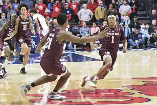 Texas A&M guard Zhuric Phelps (1) and Texas A&M forward Pharrel Payne (21) celebrate the win over Mississippi during the second half of an NCAA college basketball game in Oxford, Miss., Wednesday, Jan. 22, 2025. (AP Photo/Bruce Newman)