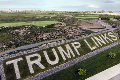FILE — Patrons play the links as a giant branding sign is displayed with flagstones at Trump Golf Links, at Ferry Point in the Bronx borough of New York, May 4, 2021. The Trump Organization has sold its right to operate a public golf course in the Bronx, city officials confirmed, Friday, Sept. 8, 2023, offloading control of the city-owned property to a company that is seeking to build a casino in New York City. (AP Photo/John Minchillo, File)