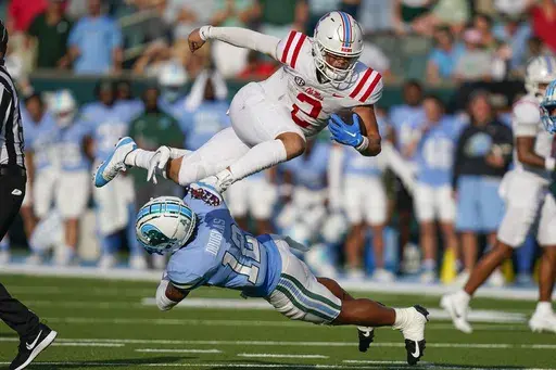 Mississippi quarterback Jaxson Dart (2) carries for a first down over Tulane defensive back DJ Douglas (12) in the second half of an NCAA college football game in New Orleans, Saturday, Sept. 9, 2023. Mississippi won 37-20. (AP Photo/Gerald Herbert)