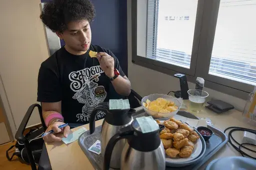College student and research subject Sam Srisatta eats a lunch of chicken nuggets and chips in his room during a study on the health effects of ultraprocessed foods at the National Institutes of Health in Bethesda, Md., on Thursday, Oct. 31, 2024. (AP Photo/Mark Schiefelbein)