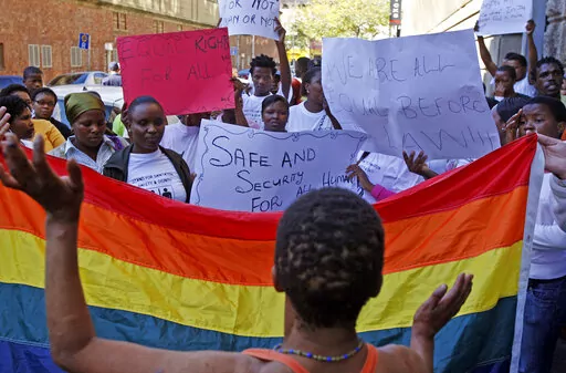 FILE - Women in Cape Town, South Africa, protest a sentence given to two men under Malawi's anti-gay legislation on May 20, 2010. Desmond Tutu is being remembered for his passionate advocacy on behalf of LGBTQ people as well as his fight for racial justice. But the South African archbishop's campaign against homophobia had limited impact in the rest of Africa. (AP Photo/Schalk van Zuydam, File)