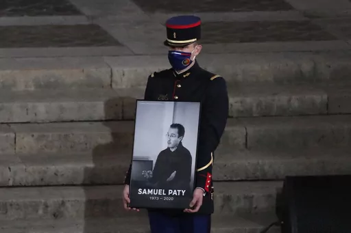 A Republican Guard holds a portrait of Samuel Paty in the courtyard of the Sorbonne university during a national memorial event, Wednesday, Oct. 21, 2020 in Paris. A French juvenile court is handing down a verdict Friday Dec.8, 2023 for six teenagers accused of involvement in the killing of teacher Samuel Paty, beheaded by an Islamic extremist after he showed caricatures of the Prophet Muhammad to his class for a debate on freedom of expression. (AP Photo/Francois Mori, Pool, File)